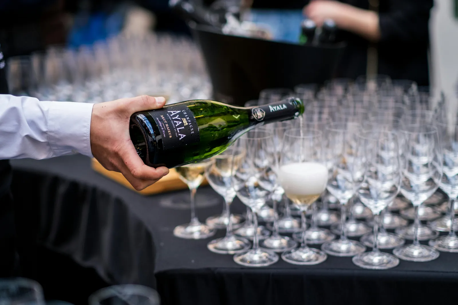 Champagne poured into rows of coupes and flutes