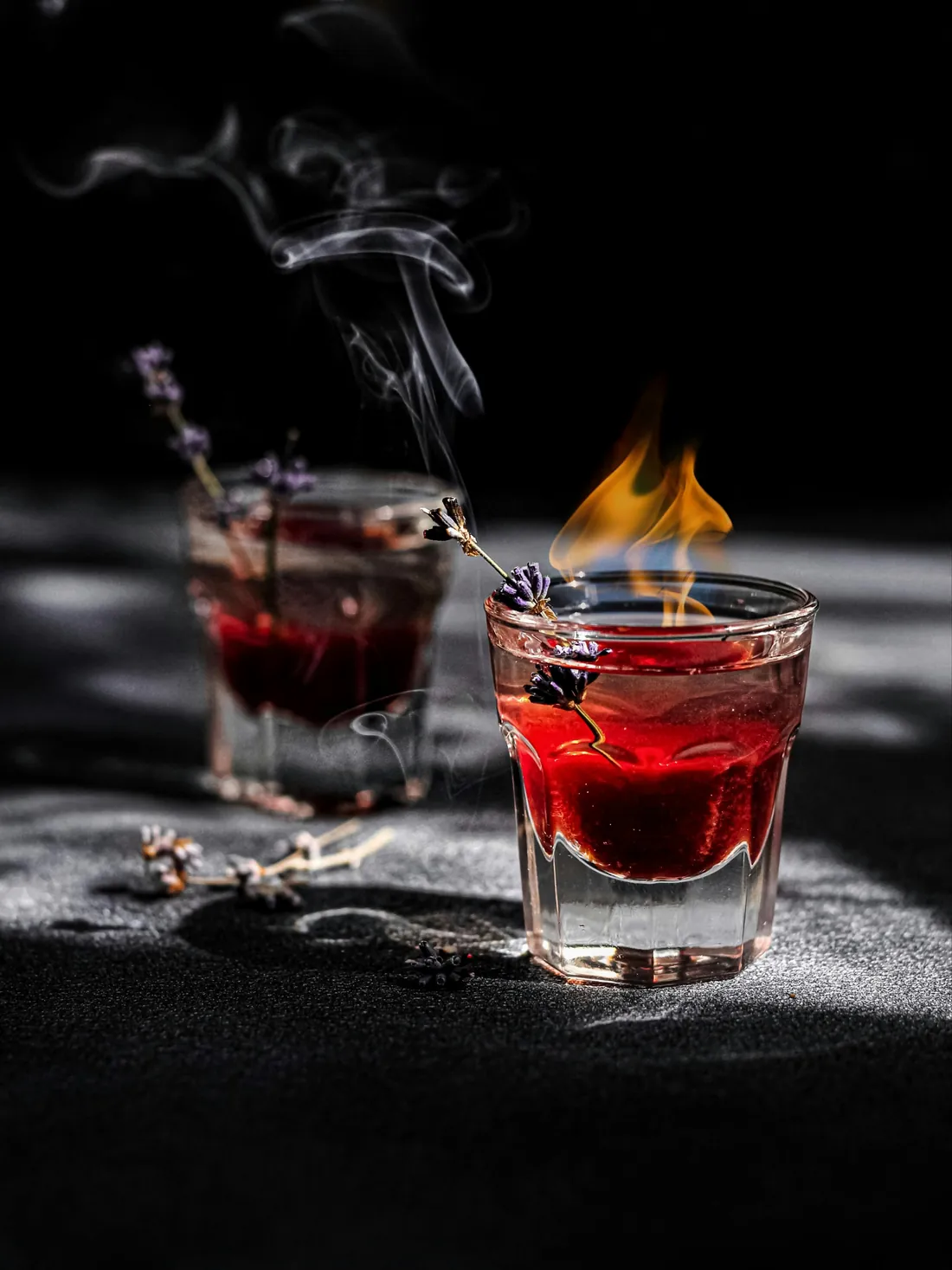 A flaming lavender cocktail with smoke rising