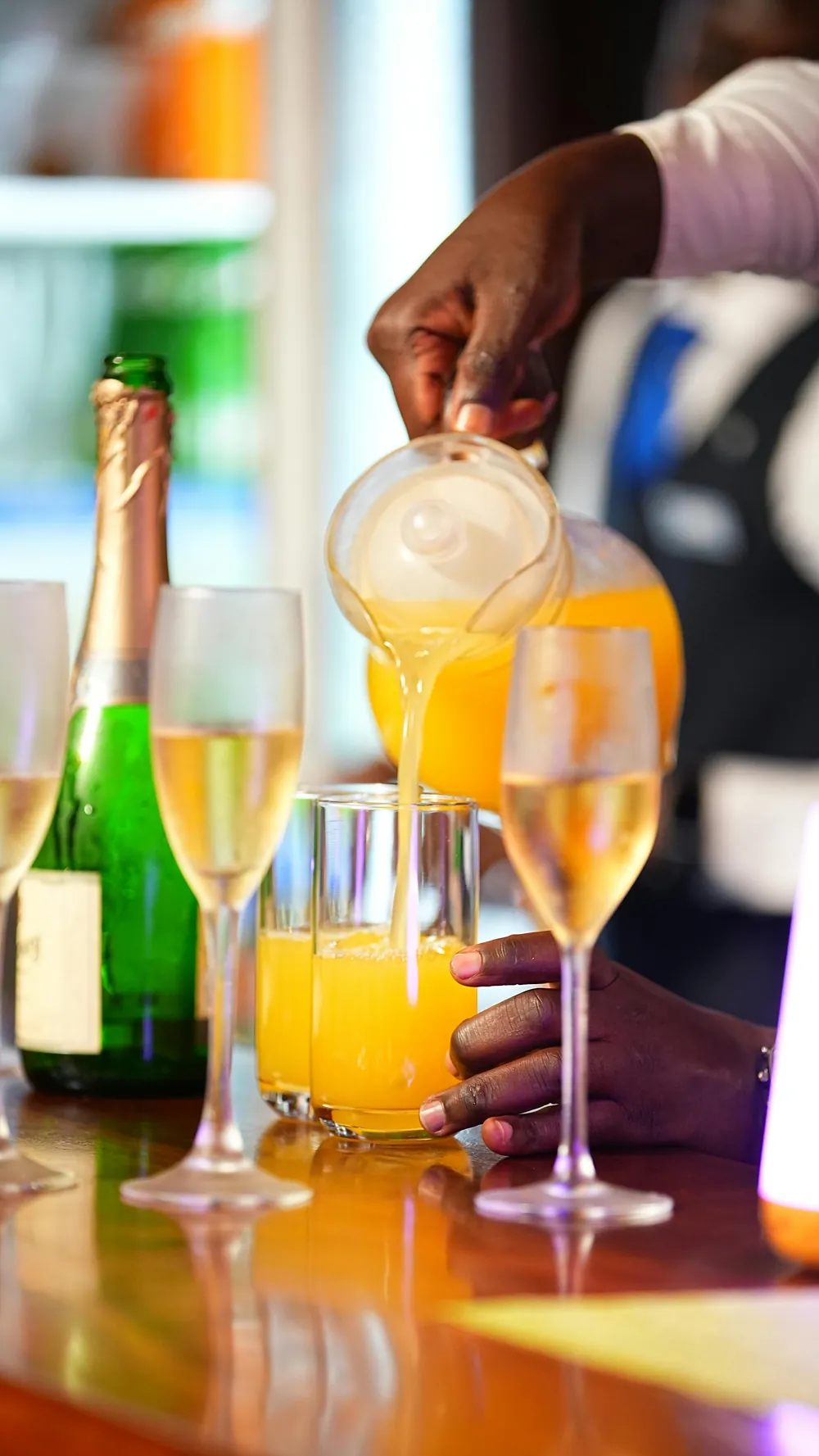 A bartender pouring mimosas at the bar