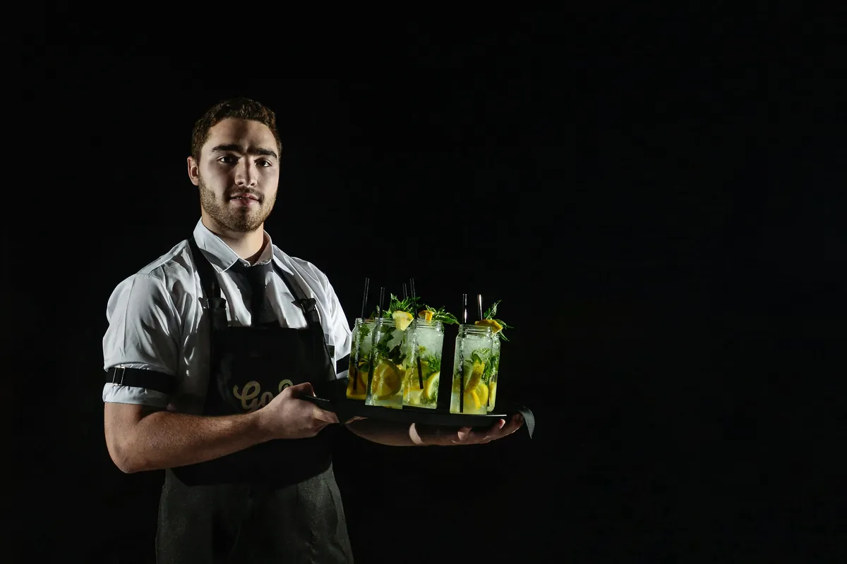 A server presenting a tray of passed cocktails